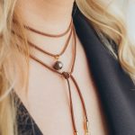 Tumši brūna aukliņa ar pērli un kristāliem